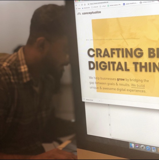 At a monitor showing the Conceptualize website